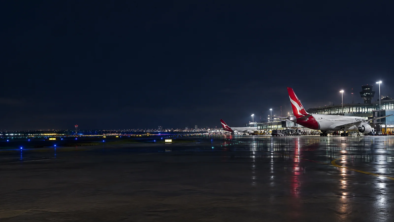 Panorama Qantas với máy bay đậu tại sân bay quốc tế và nhận diện hãng rõ ràng