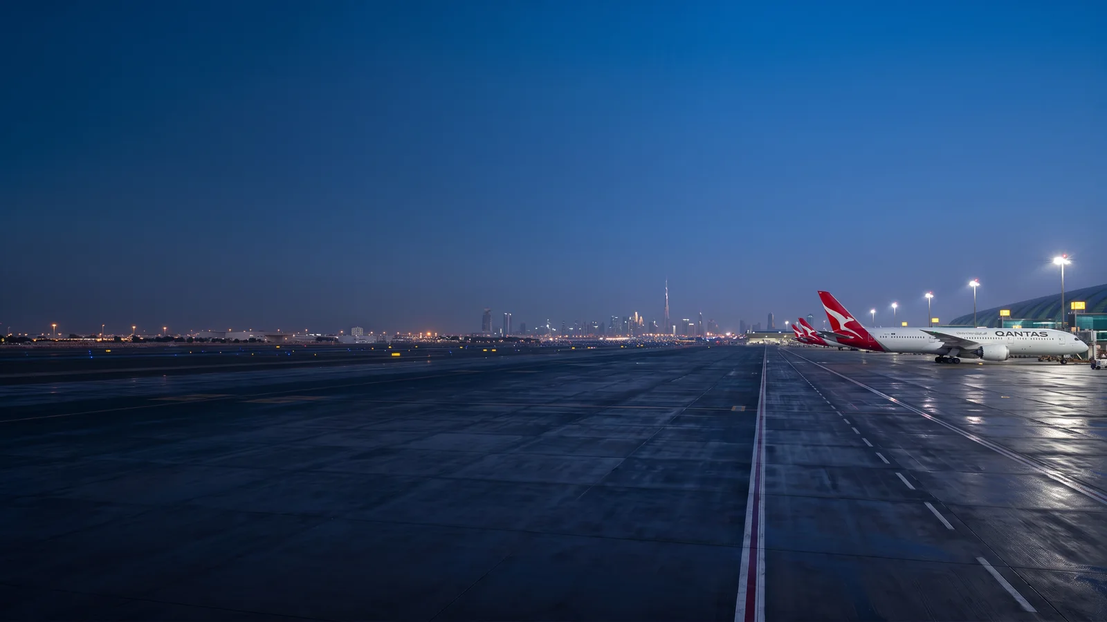 Panorama Qantas với máy bay đậu tại sân bay quốc tế và nhận diện hãng rõ ràng
